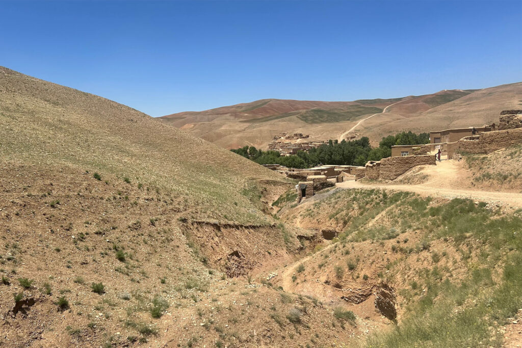 Utsikt över en by omringad av berg i Afghanistan.