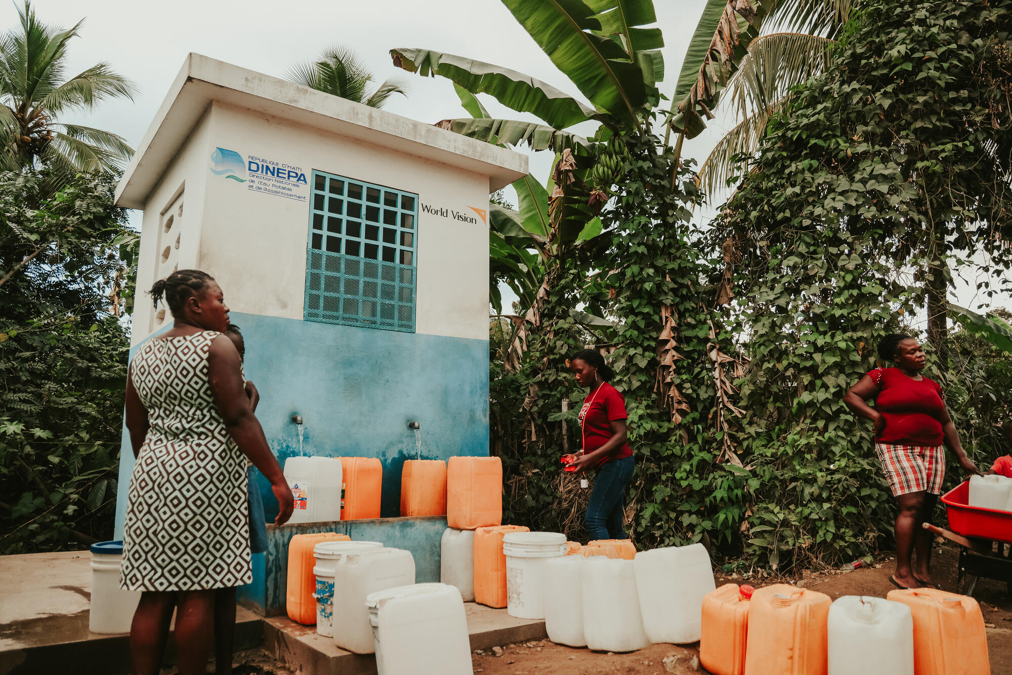 Kvinnor i Haiti hämtar vatten från en vattenstation byggd med World Visions hjälp.